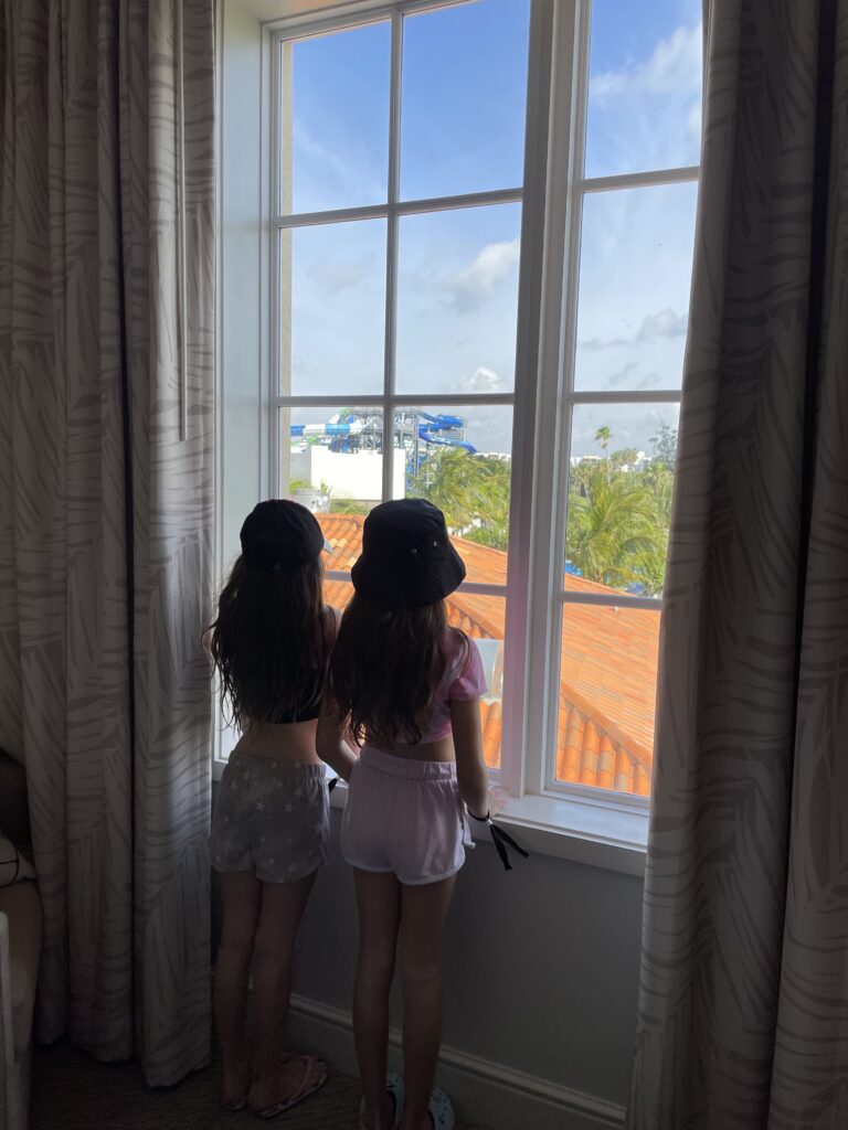 two girls looking out a hotel window